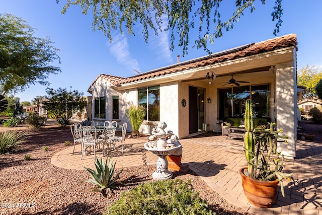 rear view of house with a tiled roof, a patio area, a ceiling fan, and stucco siding