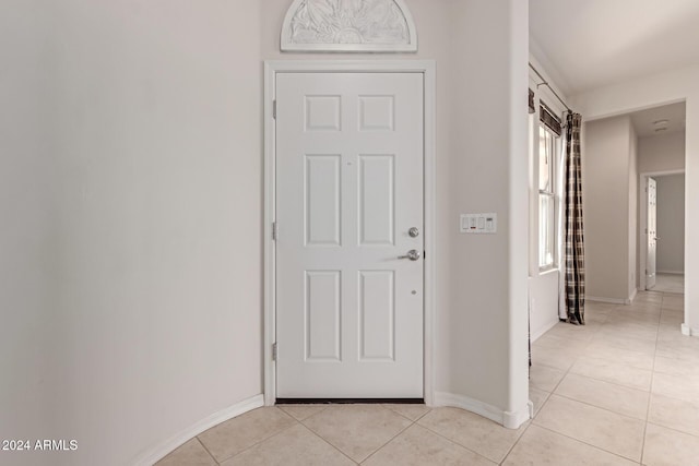 corridor featuring light tile patterned floors and baseboards