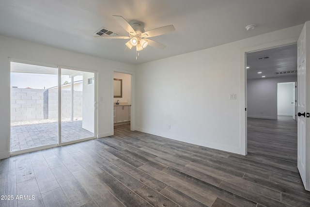 unfurnished room featuring sink, ceiling fan, and dark hardwood / wood-style floors