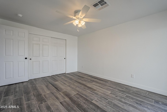 unfurnished bedroom featuring ceiling fan, dark wood-type flooring, and a closet