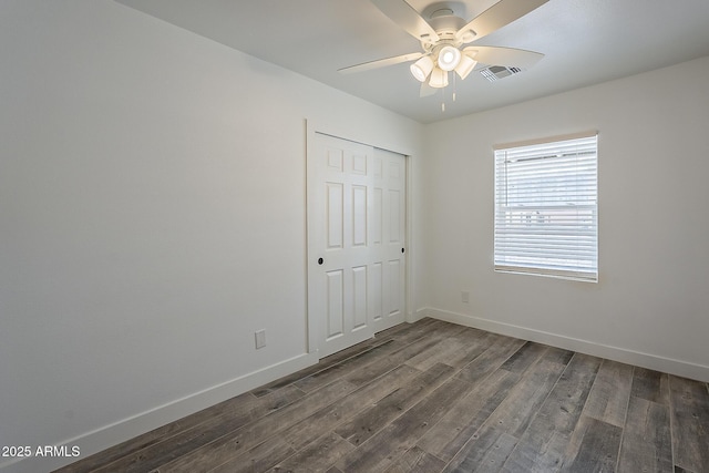 unfurnished bedroom featuring a closet, ceiling fan, and dark wood-type flooring