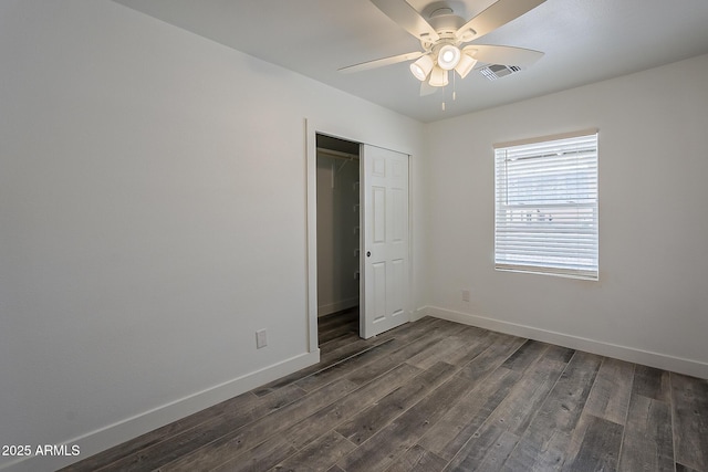 unfurnished bedroom featuring ceiling fan, dark hardwood / wood-style flooring, and a closet