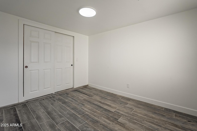 unfurnished bedroom featuring a closet and dark wood-type flooring