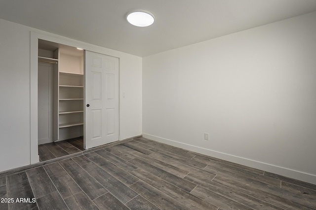 unfurnished bedroom featuring a closet and dark hardwood / wood-style floors