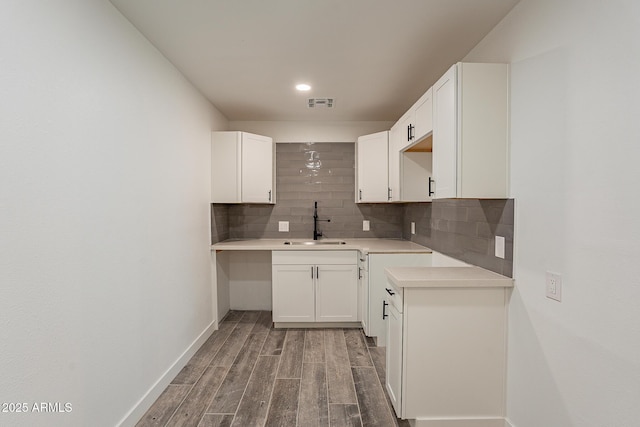 kitchen with white cabinets, backsplash, and sink