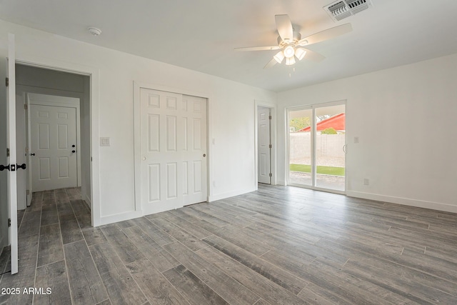 unfurnished bedroom with ceiling fan, dark hardwood / wood-style flooring, a closet, and access to exterior