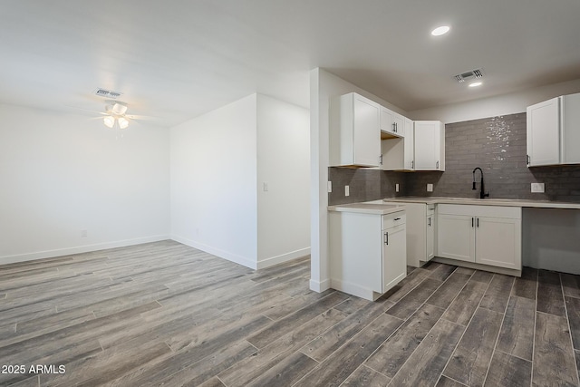 kitchen featuring white cabinets, ceiling fan, hardwood / wood-style floors, and sink