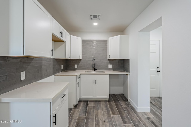 kitchen with sink, white cabinetry, and backsplash