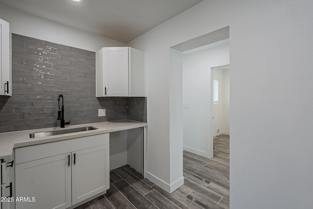 kitchen with sink, white cabinets, decorative backsplash, and dark wood-type flooring