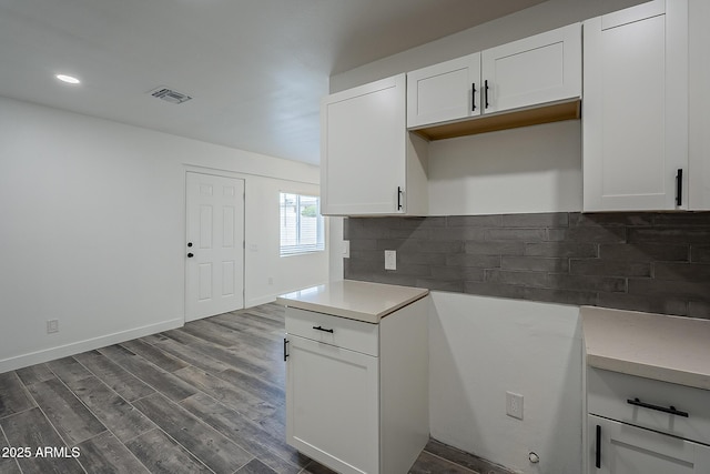 kitchen with hardwood / wood-style floors, tasteful backsplash, and white cabinetry