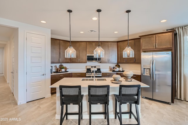 8128 E Paloma Ave, Mesa, AZ 85212 - kitchen featuring stainless steel appliances, light countertops, hanging light fixtures, a breakfast bar area, and recessed lighting