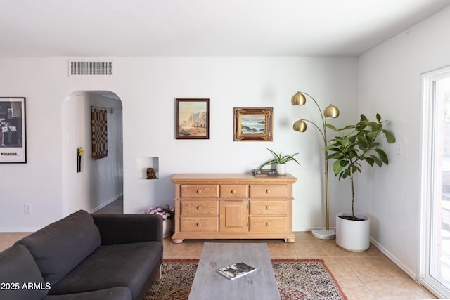1330 E Monte Vista Rd, Phoenix, AZ 85006 - living room with arched walkways, light tile patterned floors, baseboards, and healthy amount of natural light