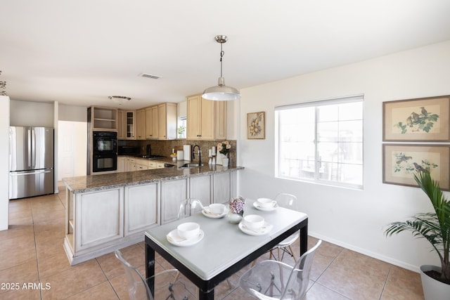 1330 E Monte Vista Rd, Phoenix, AZ 85006 - kitchen featuring freestanding refrigerator, a sink, backsplash, light tile patterned floors, and a peninsula