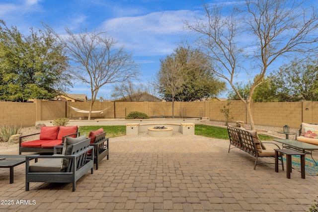 view of patio with an outdoor living space with a fire pit