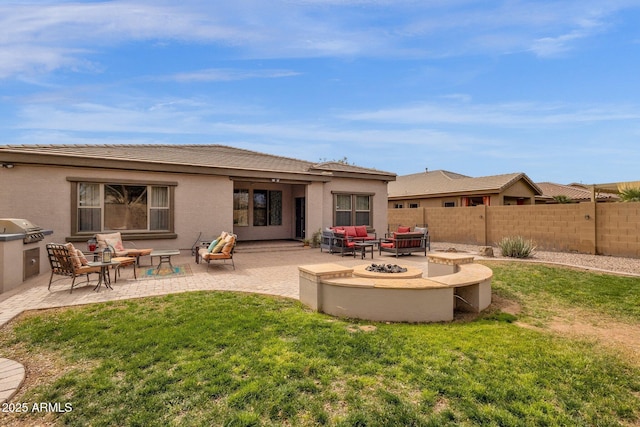 rear view of property featuring a lawn, an outdoor living space with a fire pit, and a patio