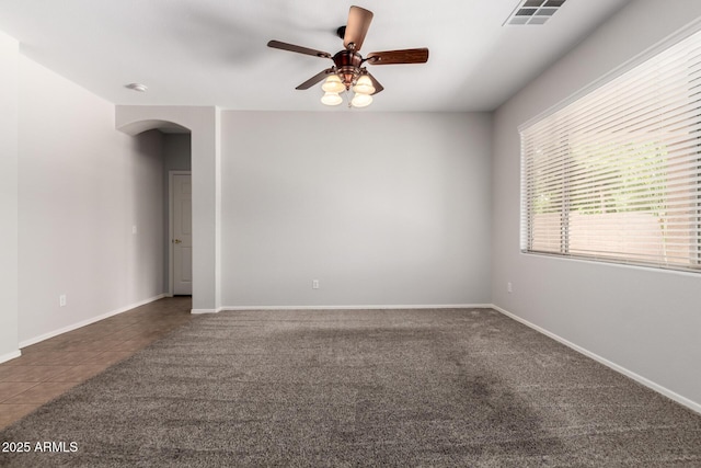 18719 E Pelican Ct, Queen Creek, AZ 85142 - carpeted empty room featuring arched walkways, ceiling fan, tile patterned flooring, and baseboards