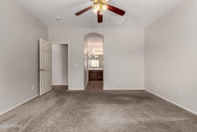 18719 E Pelican Ct, Queen Creek, AZ 85142 - unfurnished bedroom with arched walkways, carpet, baseboards, connected bathroom, and ceiling fan