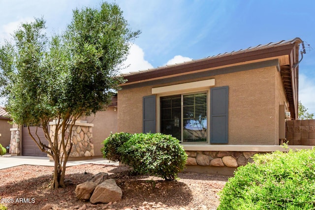 18719 E Pelican Ct, Queen Creek, AZ 85142 - view of property exterior with stucco siding, driveway, an attached garage, and stone siding