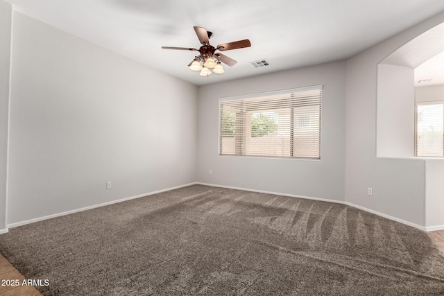 18719 E Pelican Ct, Queen Creek, AZ 85142 - carpeted spare room featuring baseboards, a ceiling fan, and arched walkways