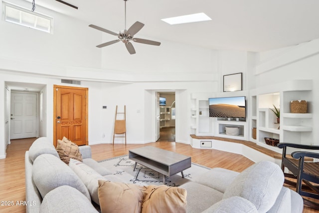 7734 E Rose Ln, Scottsdale, AZ 85250 - living area featuring light wood-type flooring, visible vents, built in shelves, a ceiling fan, and high vaulted ceiling