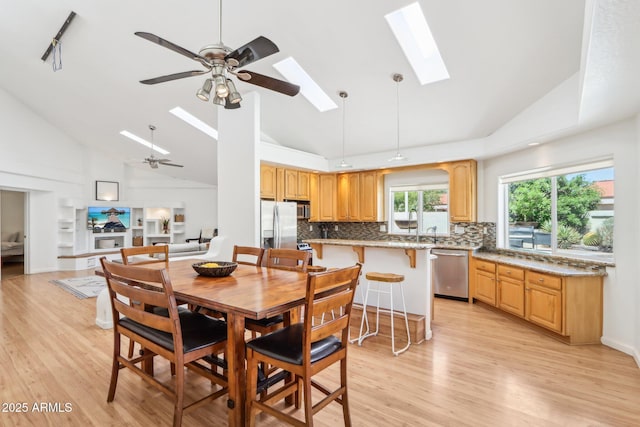 7734 E Rose Ln, Scottsdale, AZ 85250 - dining space featuring high vaulted ceiling, a ceiling fan, light wood-style floors, and a skylight
