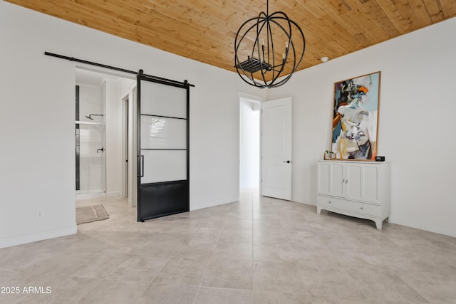 spare room featuring a barn door, a notable chandelier, and wood ceiling