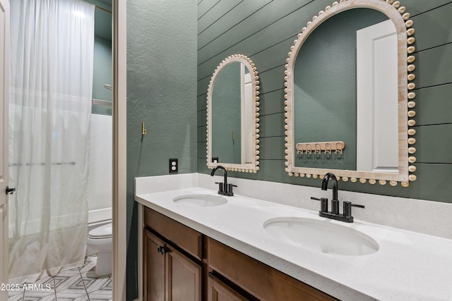 full bathroom featuring vanity, washtub / shower combination, wooden walls, and toilet