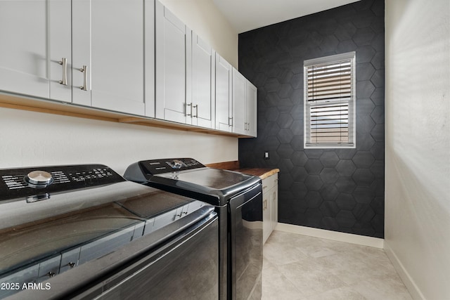 laundry area featuring cabinets, washer and clothes dryer, and light tile patterned floors