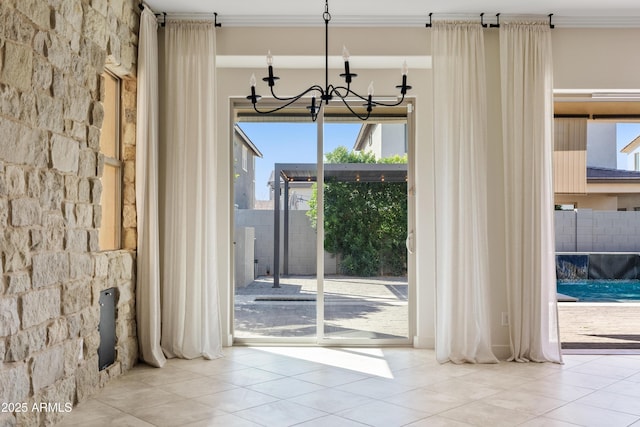 interior space featuring tile patterned flooring, a notable chandelier, and crown molding