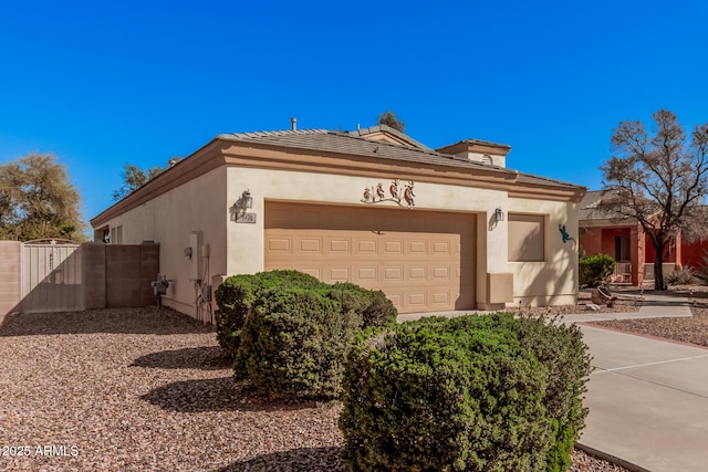 view of home's exterior with stucco siding, an attached garage, and a gate