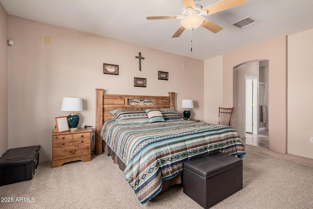 bedroom with arched walkways, visible vents, ceiling fan, and carpet