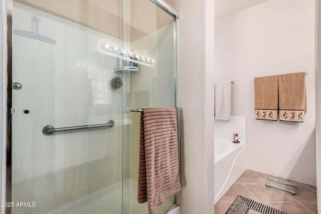 full bath featuring tile patterned floors, a garden tub, and a shower stall