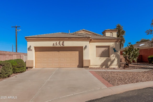 view of front facade with a tiled roof, stucco siding, an attached garage, and concrete driveway