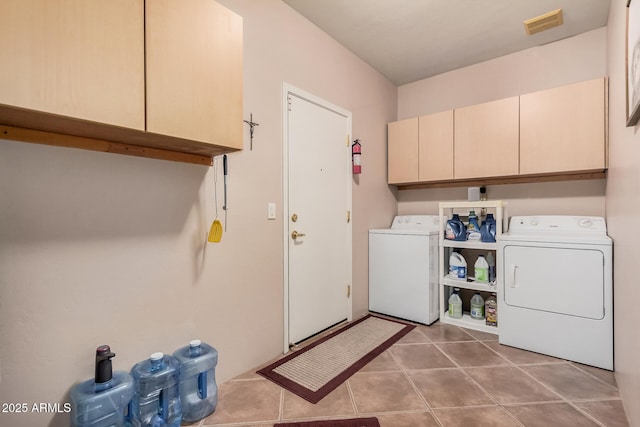 laundry area with visible vents, cabinet space, washing machine and dryer, and tile patterned flooring