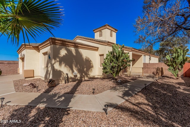 view of front of property featuring stucco siding and fence