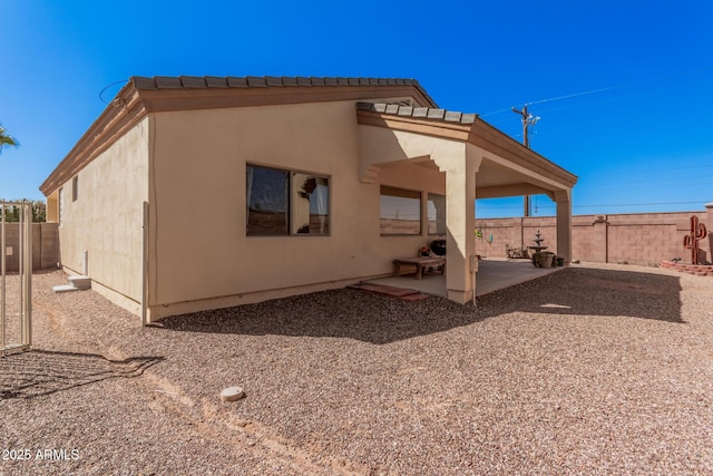 back of property featuring a patio area, fence, and stucco siding