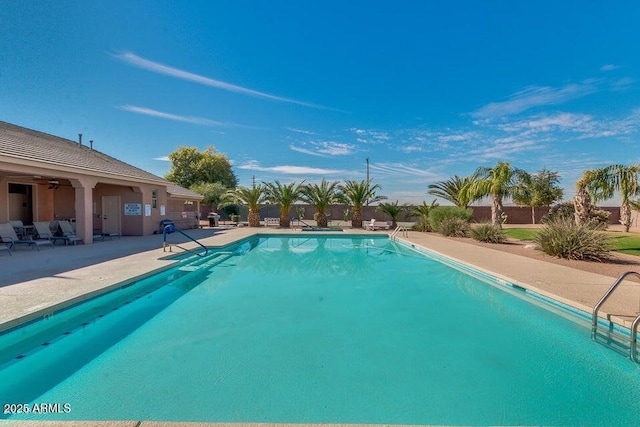 community pool featuring a ceiling fan, a patio area, and fence