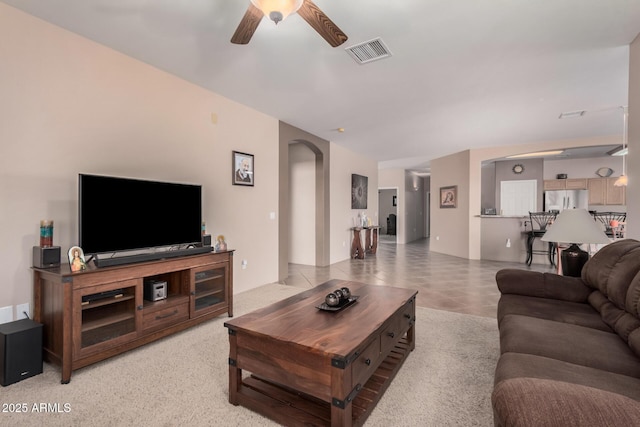 living room with visible vents, arched walkways, and a ceiling fan