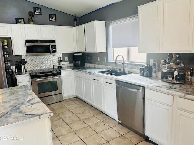 kitchen with white cabinets, light tile patterned floors, sink, and appliances with stainless steel finishes