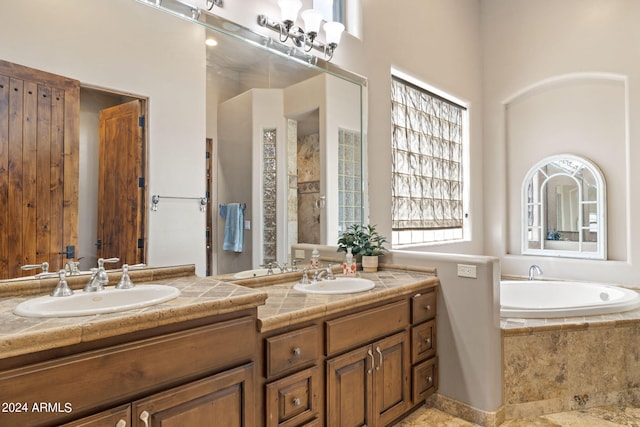 bathroom featuring tiled tub and vanity