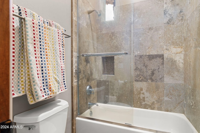 bathroom featuring shower / bath combination with glass door and toilet