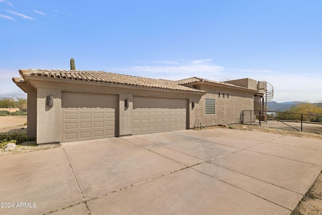 view of home's exterior with a garage and a mountain view