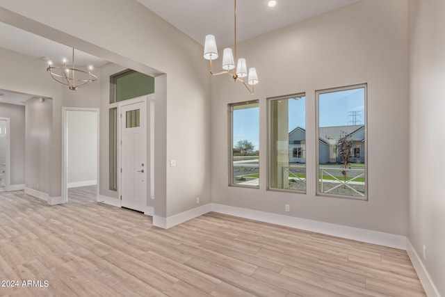 1229 N 106th Pl, Mesa, AZ 85207 - empty room with a chandelier, light wood-type flooring, and baseboards