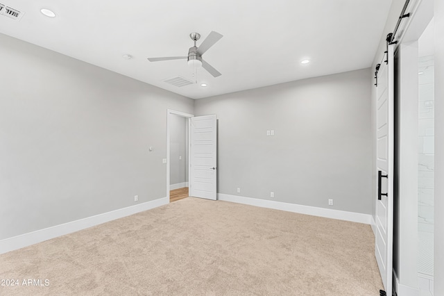 1229 N 106th Pl, Mesa, AZ 85207 - unfurnished bedroom with a barn door, light carpet, recessed lighting, baseboards, and a ceiling fan