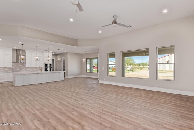 1229 N 106th Pl, Mesa, AZ 85207 - unfurnished living room featuring a ceiling fan, recessed lighting, light wood finished floors, baseboards, and a sink