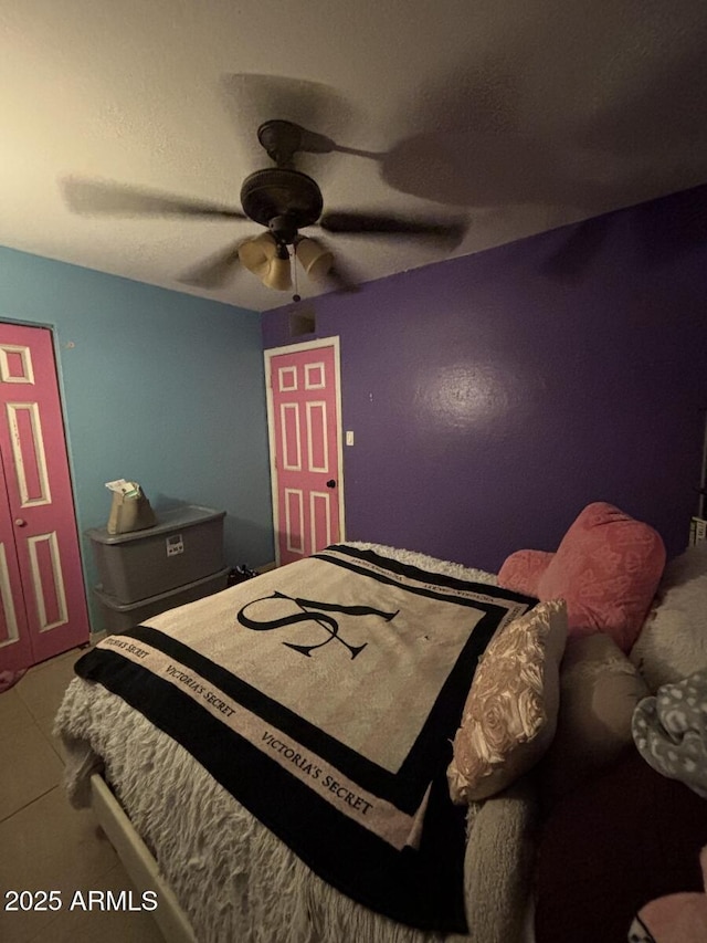 tiled bedroom with a ceiling fan