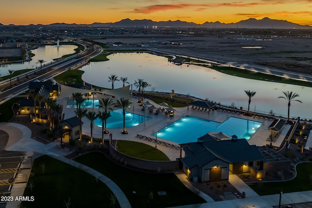 aerial view at dusk featuring a water view