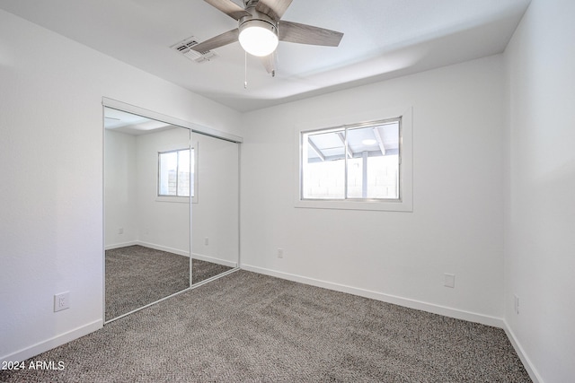 unfurnished bedroom featuring a closet, ceiling fan, and dark colored carpet