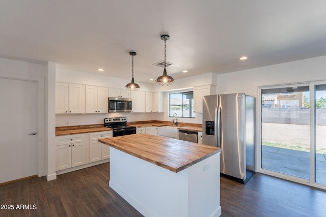2818 E Villa Rita Dr, Phoenix, AZ 85032 - kitchen with butcher block counters, stainless steel appliances, dark wood finished floors, white cabinetry, and recessed lighting
