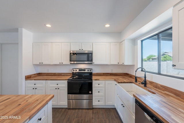 2818 E Villa Rita Dr, Phoenix, AZ 85032 - kitchen with butcher block countertops, stainless steel appliances, dark wood-style flooring, white cabinets, and recessed lighting